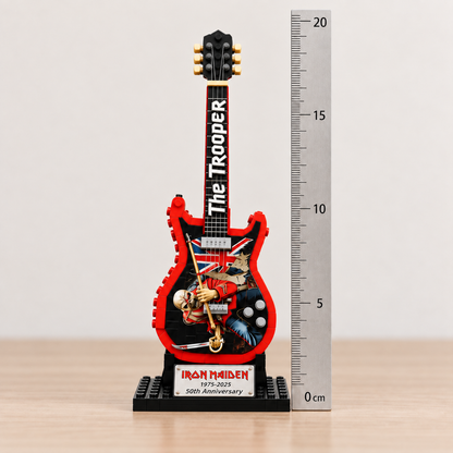 Iron Maiden The Trooper miniature guitar beside a centimetre ruler, showing its approximate dimensions of 19.5 × 6.5 × 10 cm.