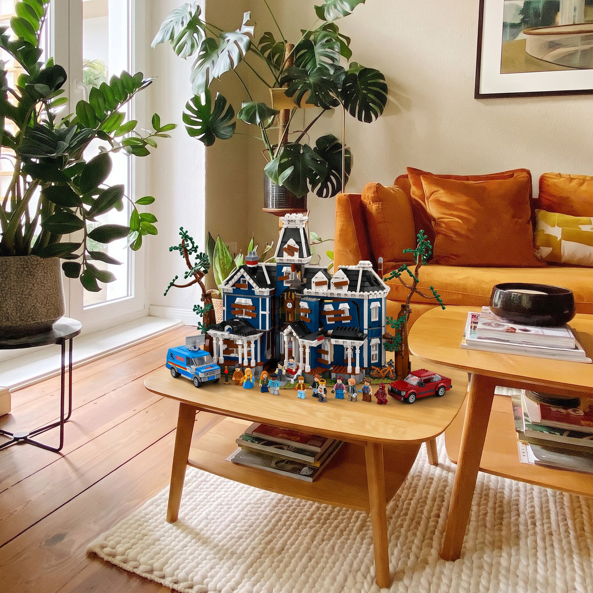 Brick-built Creel House from Stranger Things on a light wooden coffee table beside an orange sofa